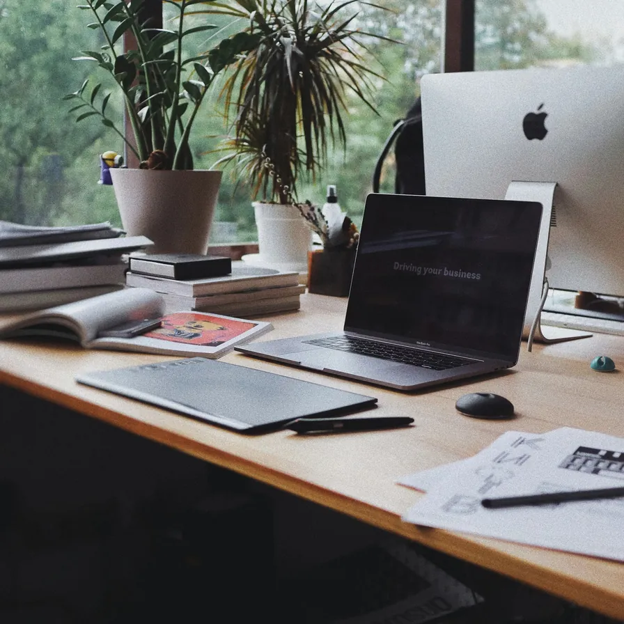 Desk with a laptop and books by a window